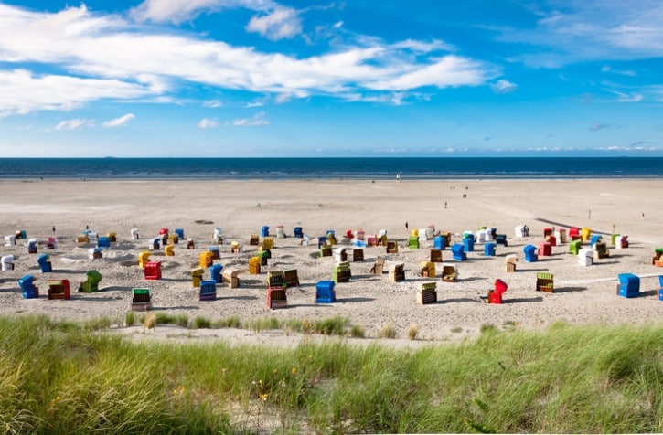 Sandstrand mit Strandkörben am Wattenmeer.