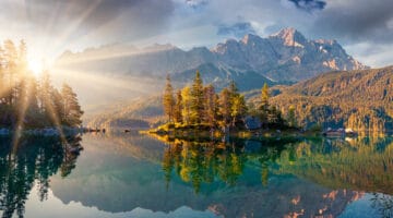 Misty summer morning on the Eibsee lake in German Alps.
