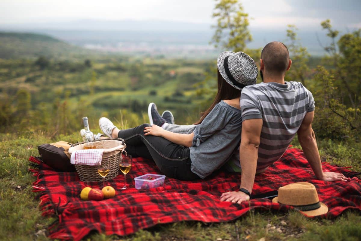 Ein Paar macht Picknick mit Ausblick, ein To-Do auf ihrer Sommer Bucket List.