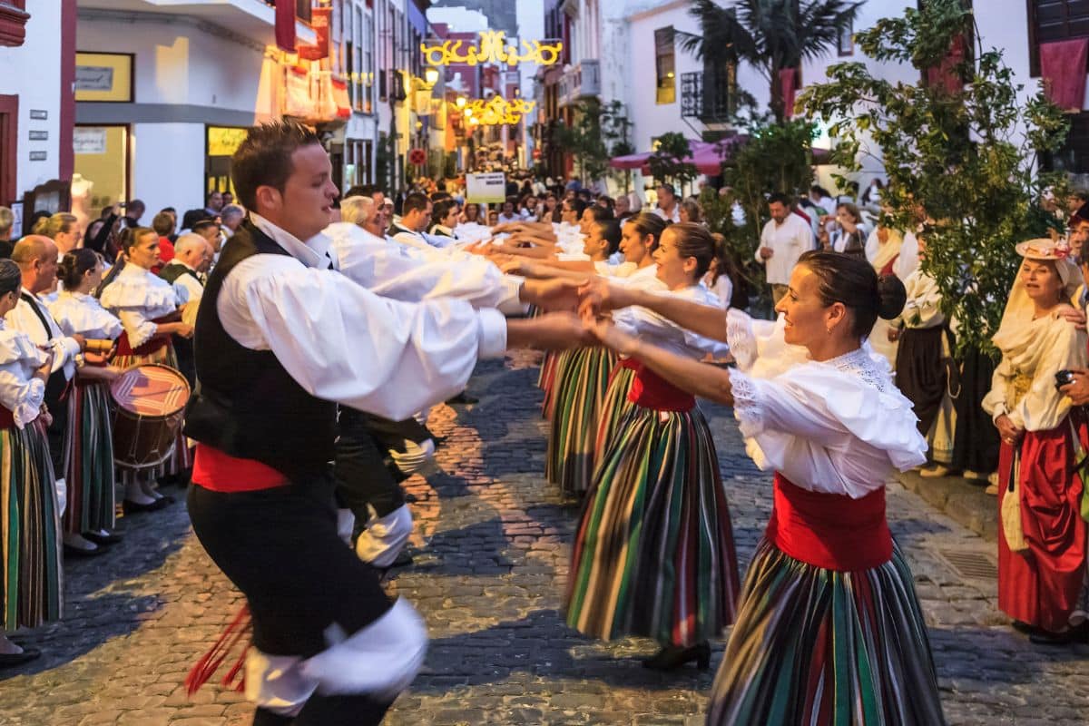 Menschen tanzen in traditioneller Kleidung auf einem Fest in Santa Cruz de la Palma