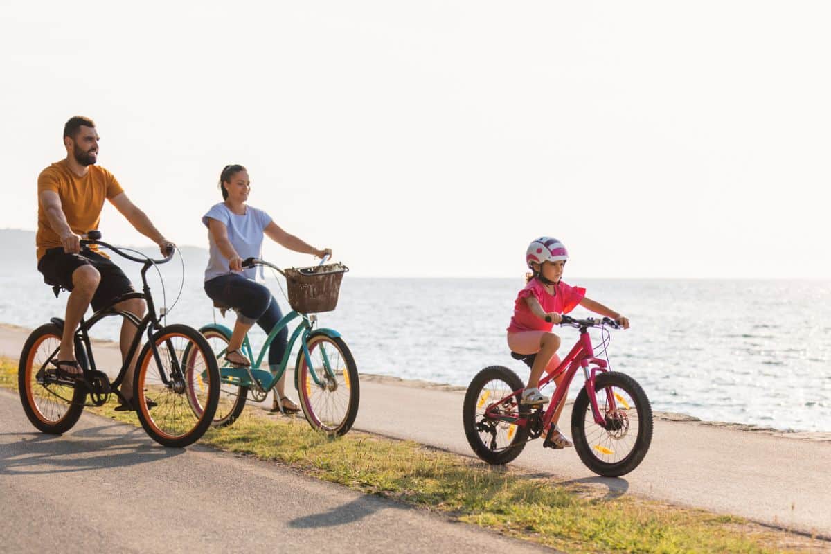 Eine Familie macht eine Fahrradtour am Strand entlang