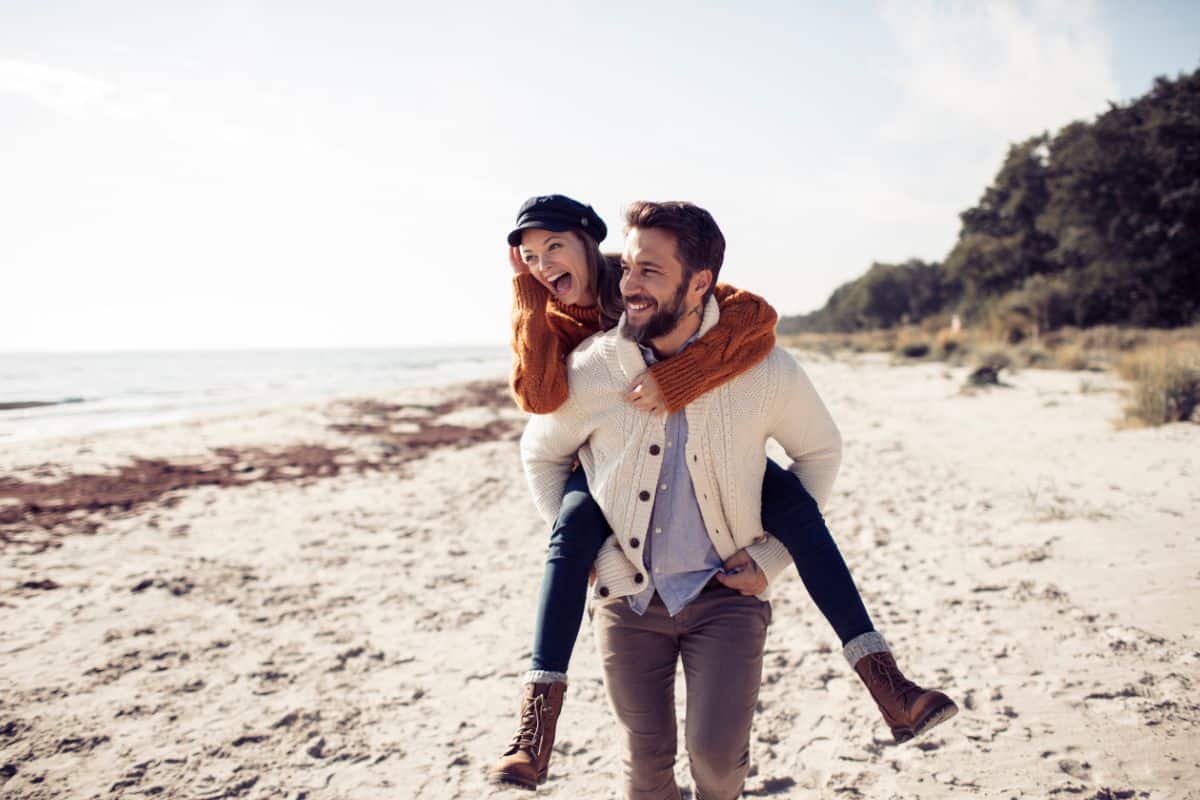 Ein Paar am Strand freut sich auf die Urlaubsziele 2026